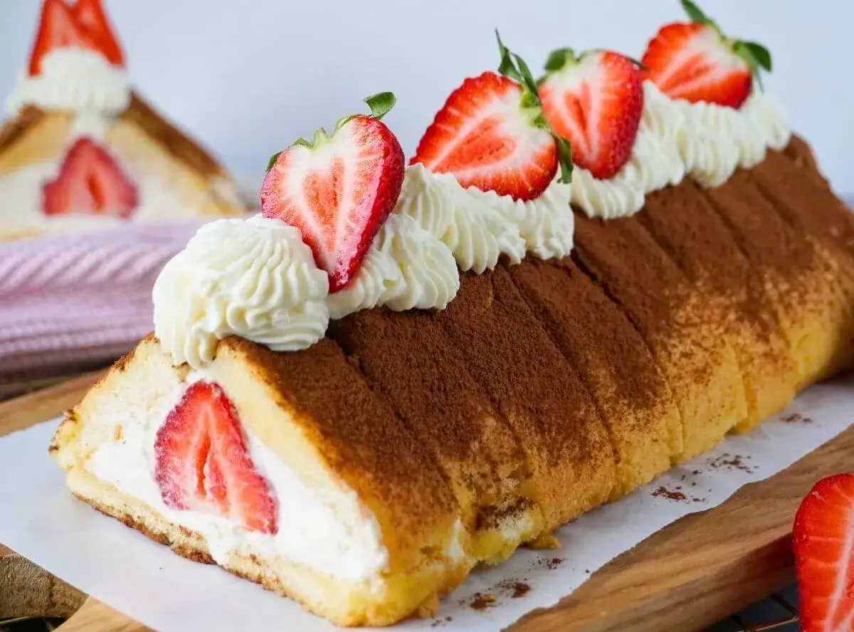 Erdbeer Tiramisu Rolle mit frischen Erdbeeren und Sahnetupfern, best&auml;ubt mit Kakaopulver. Ein s&uuml;&szlig;er Genuss!