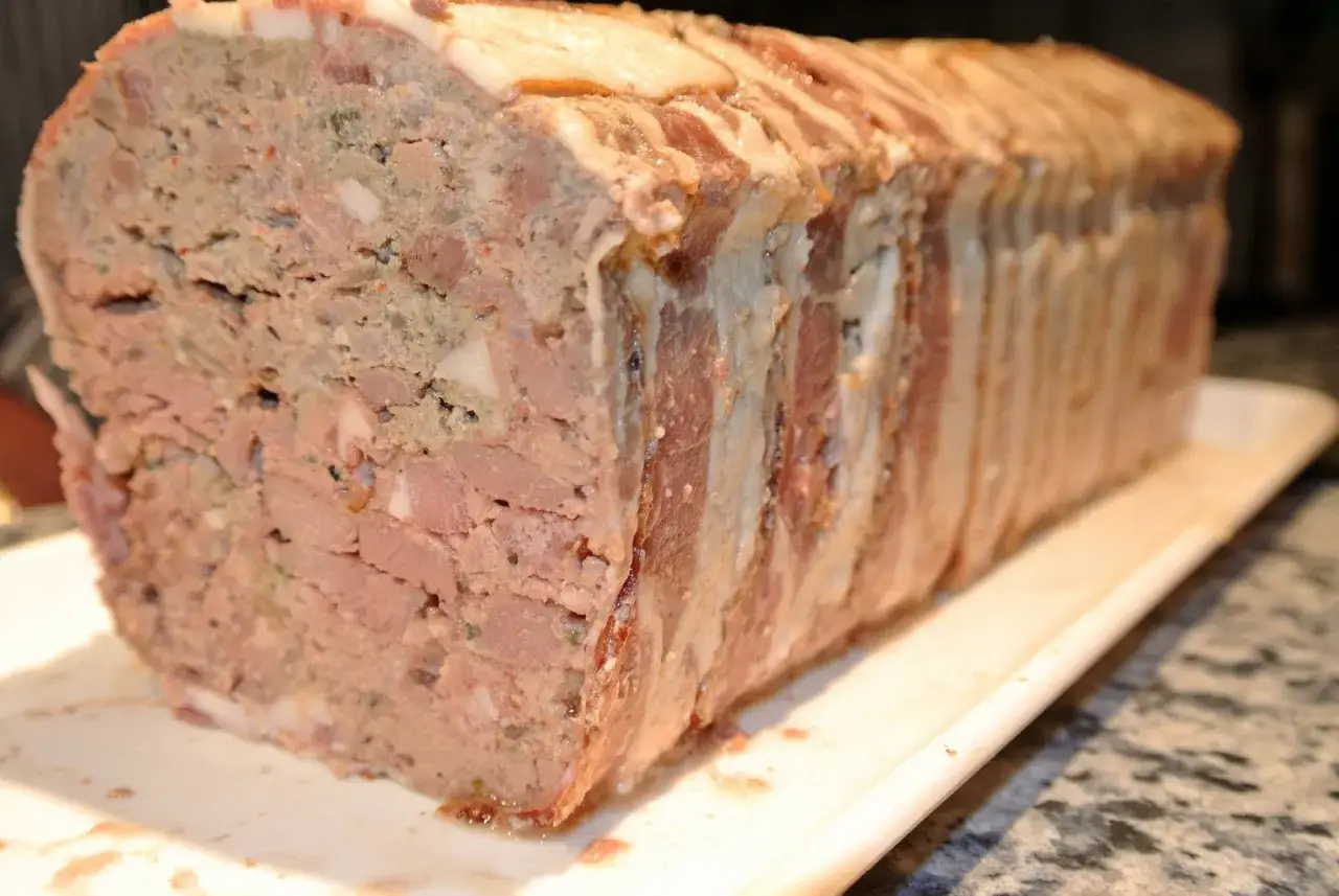 Herzhaftes Terrinen-Rezept: Ein Laib aus Fleisch und Speck, bereit zum Backen.