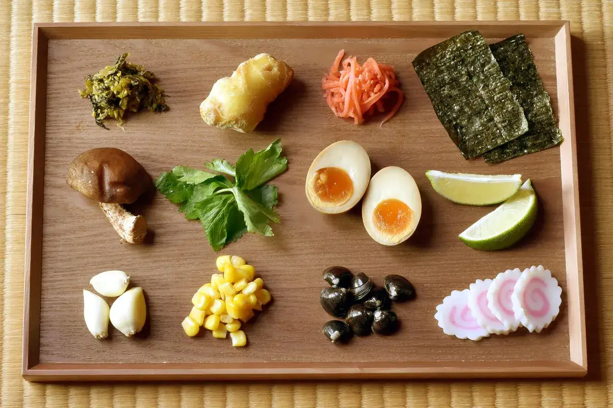 Zutaten für Shoyu Ramen: Shiitake, Ei, Mais, Ingwer, Knoblauch, Nori, Limette, Muscheln und Narutomaki.