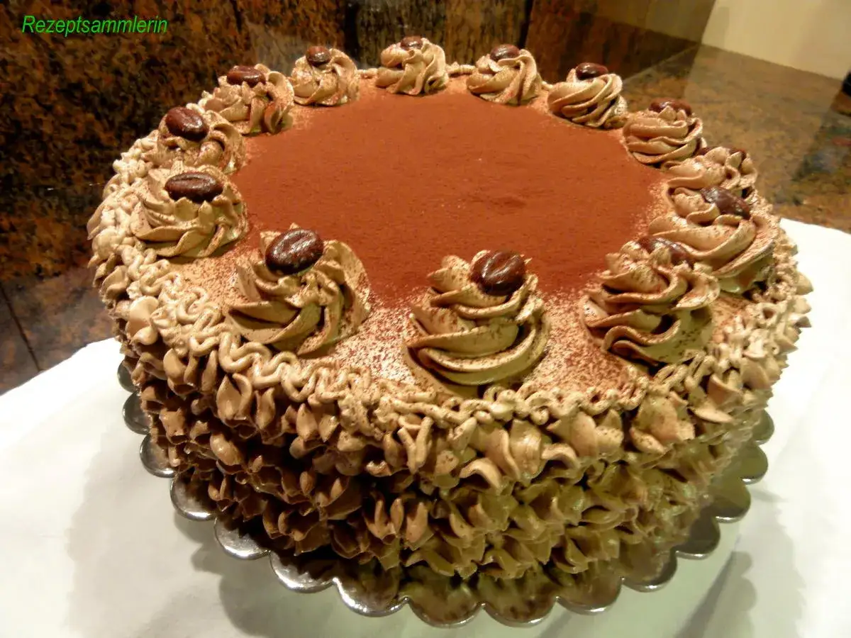 Eine k&ouml;stliche Mokkatorte mit Buttercreme, verziert mit Kaffeebohnen und Kakaopulver.