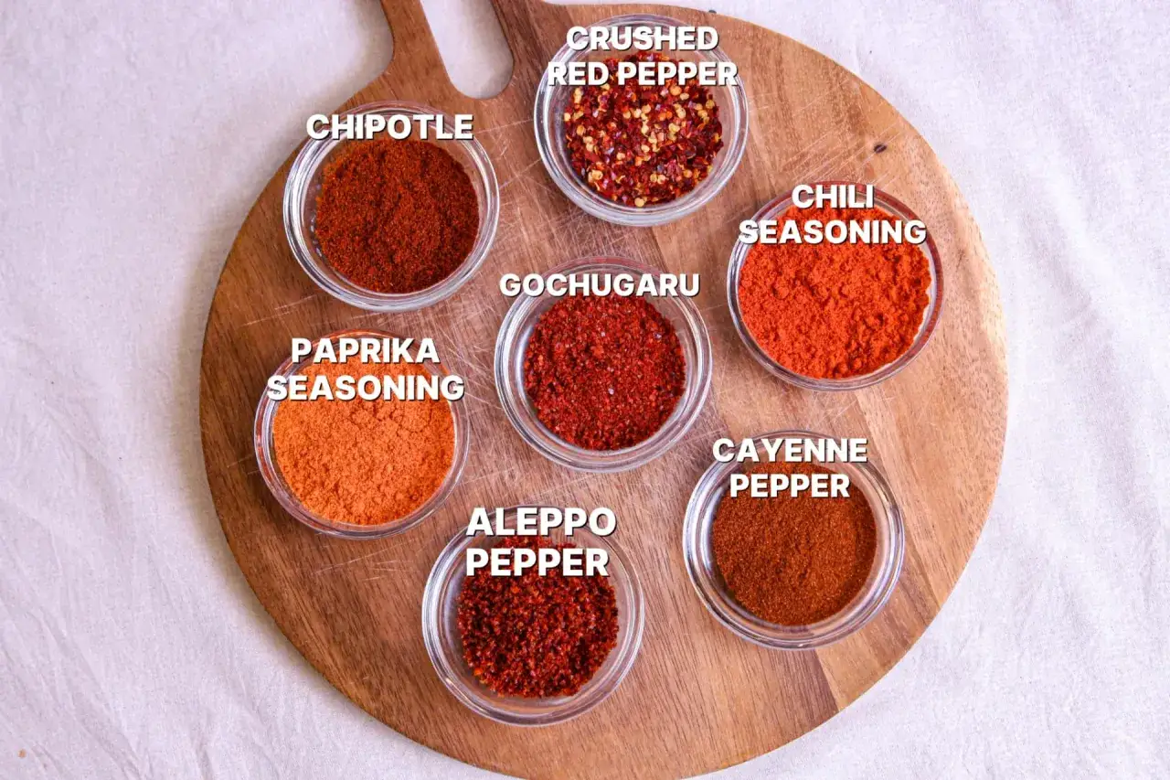 Sch&auml;lchen mit verschiedenen Chilipulvern: Chipotle, Paprika, Gochugaru, Aleppo Pepper, Cayenne, Chili Seasoning, Crushed Red Pepper. Eine Auswahl an pul biber Alternativen.