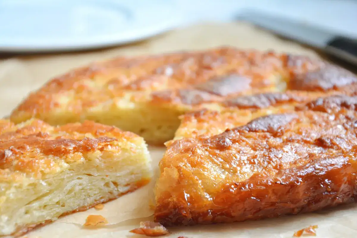 Saftiges Gateau Breton mit karamellisierter Kruste, auf Backpapier serviert.
