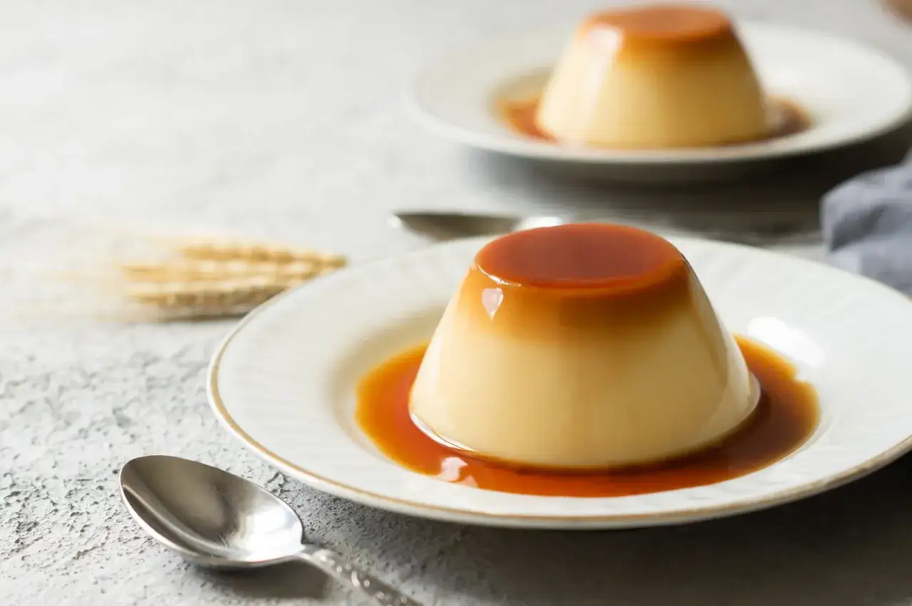 Zwei k&ouml;stliche flan kuchen mit Karamellsauce auf Tellern, bereit zum Genie&szlig;en.