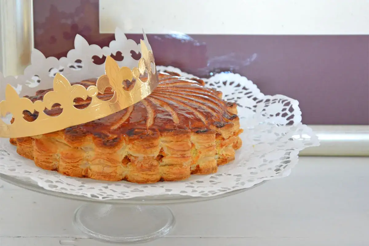 Goldene Krone auf einer köstlichen Galette des Rois, bereit zum Teilen und Feiern.
