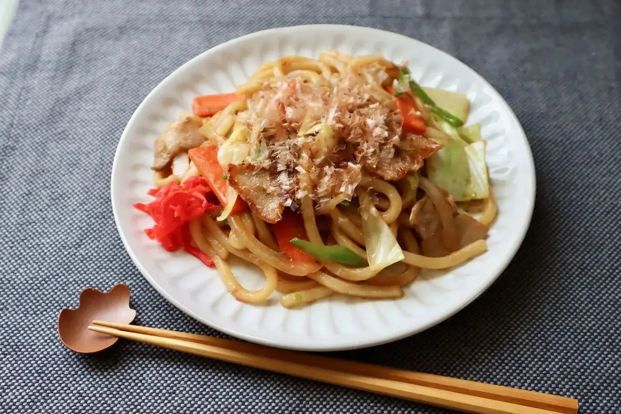 Yaki Udon mit Schweinefleisch, Karotten und Kohl, garniert mit Bonitoflocken. Ein k&ouml;stliches japanisches Gericht.