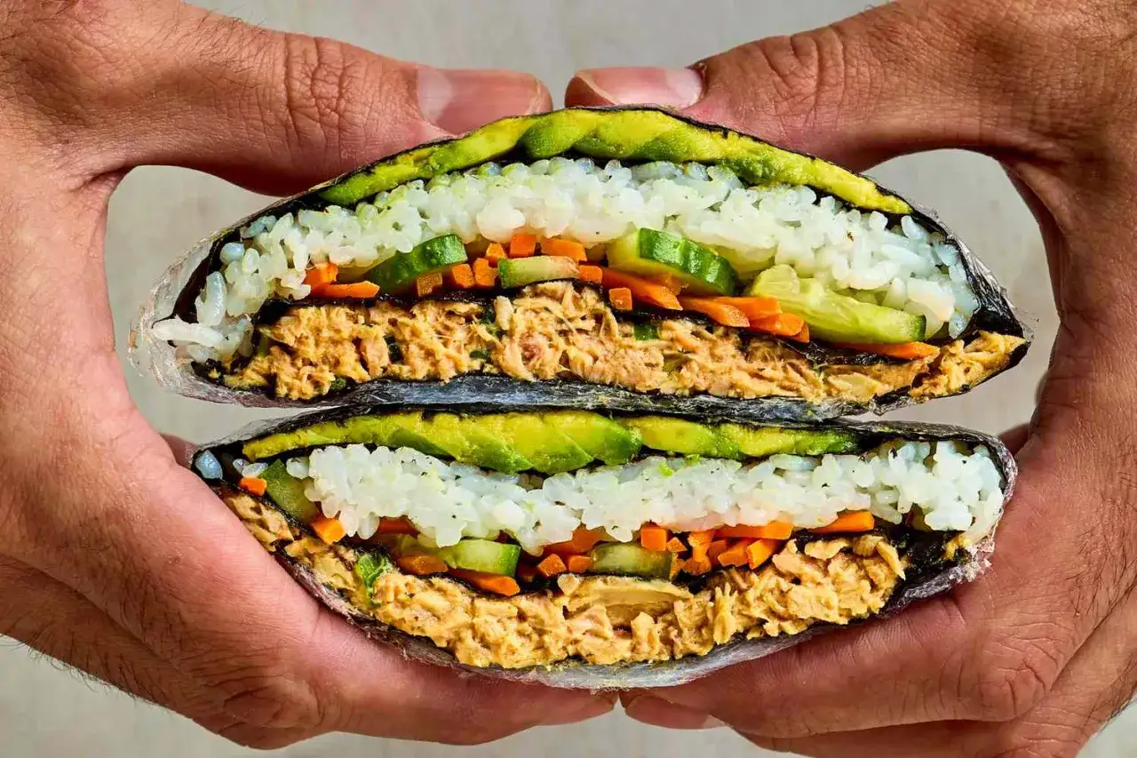 Ein &uuml;ppiger Sushi-Sandwich mit Reis, Avocado, Gurke, Karotten und Thunfisch, umh&uuml;llt von Nori-Algen.
