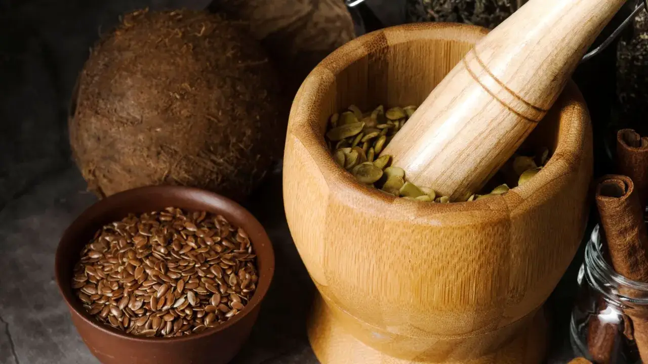 M&ouml;rser mit K&uuml;rbiskernen, Schale mit Leinsamen und Kokosnuss. Die Fenchelsamen Wirkung wird oft f&uuml;r Verdauung und Wohlbefinden gesch&auml;tzt.