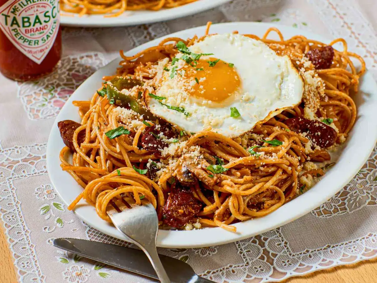 Spaghetti Napolitan mit Spiegelei, Wurst und Parmesan. Ein herzhaftes Gericht, das Lust auf mehr macht.