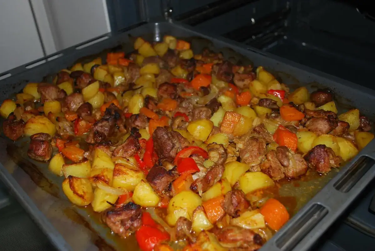 Herzhaftes Gericht aus Kartoffeln, Fleischst&uuml;cken, Karotten und Paprika auf einem Backblech, bereit f&uuml;r den Ofen. Ein rustikaler pot pie.
