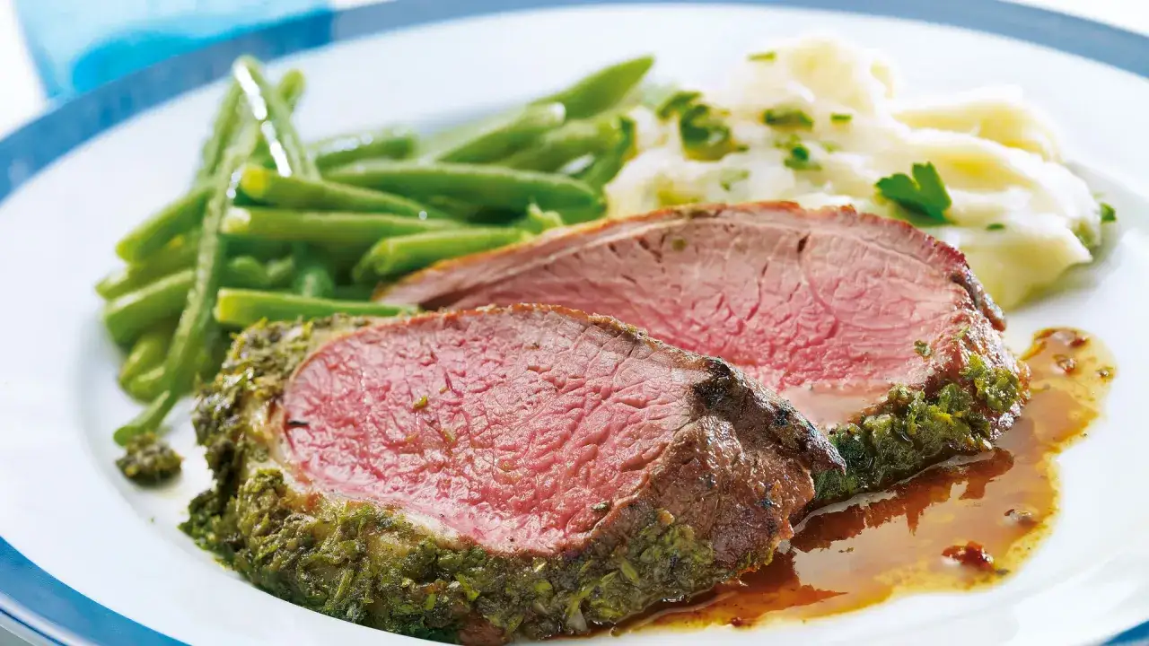 Saftiger Lammbraten mit Kr&auml;uterkruste, dazu gr&uuml;ne Bohnen und Kartoffelp&uuml;ree. Ein k&ouml;stliches Lammbraten Rezept f&uuml;r besondere Anl&auml;sse.