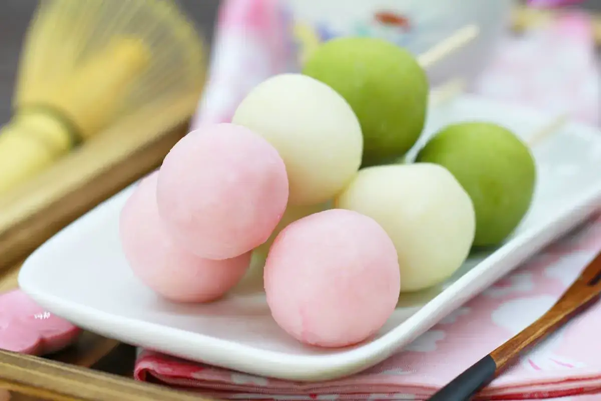 Bunte Hanami Dango auf einem Teller, bereit zum Genie&szlig;en.