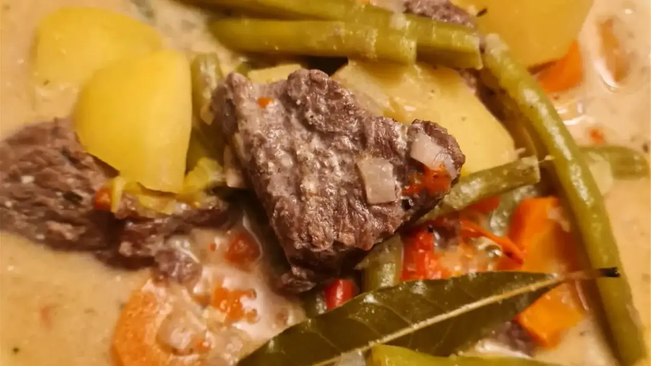 Herzhaftes Gulasch mit Kartoffeln, grünen Bohnen und Karotten, verfeinert mit Lorbeerblatt für die volle Wirkung.