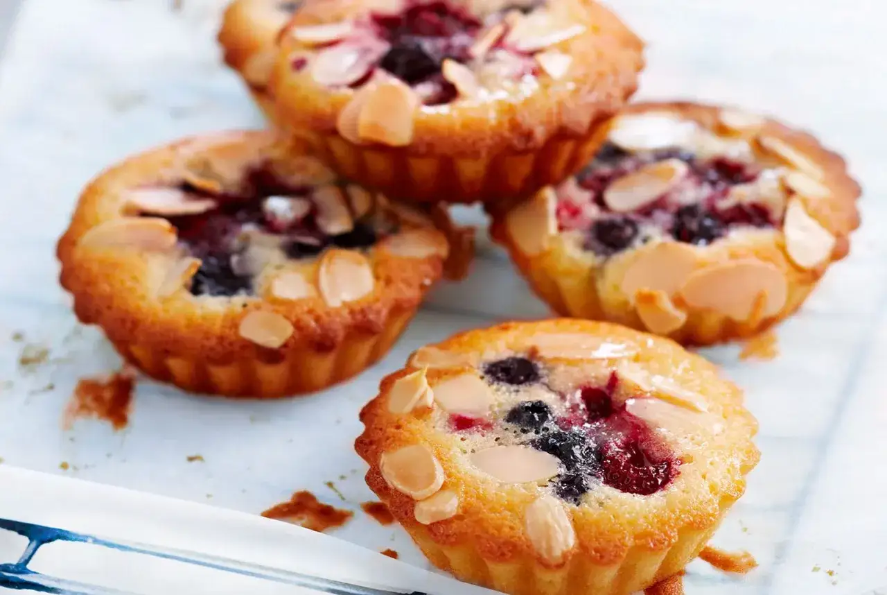 Vier kleine K&uuml;chlein mit Beeren und Mandelbl&auml;ttchen, ein k&ouml;stliches Financier Rezept.