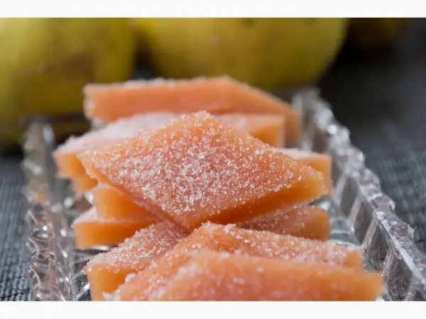 Süßes Quittenbrot, mit Zucker bestreut, auf einem Kristallteller. Ein köstliches Rezept für Quittenbrot.