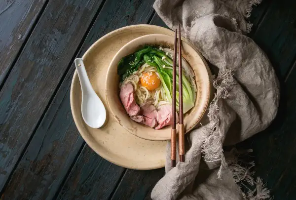 Schüssel mit Udon-Nudeln, Rindfleisch, Gemüse und Ei. Ein gesundes Gericht, das Lust auf mehr macht.