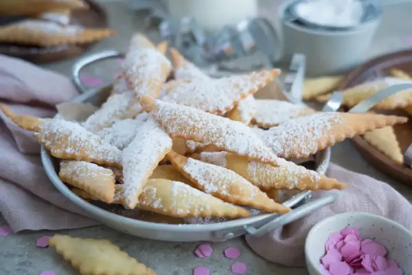 Leckere, knusprige Mutzen, bestäubt mit Puderzucker, warten auf Genießer. Was sind Mutzen? Diese frittierten Teigteilchen sind ein süßer Genuss!